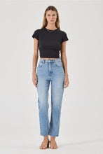 Woman wearing a black t-shirt and light blue jeans on a white background