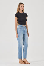 Woman wearing a black t-shirt and light blue jeans on a white background
