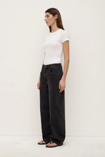 Woman wearing a white t-shirt and black pants on a white background