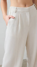 Beige pants worn by a person on a plain background