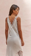 Woman wearing a white lace nightgown against a pink background
