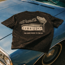 Black t-shirt with a graphic design on a blue car